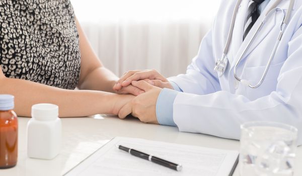 Hand of doctor comforting her female patient