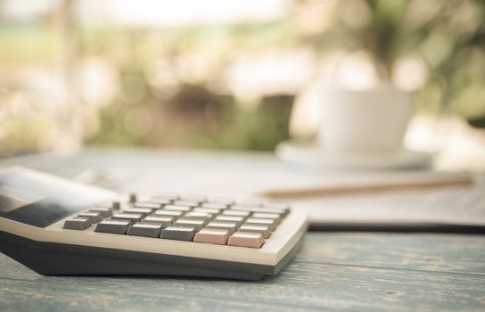 Calculator on the table in the backyard. finance,account,economy at home concepts. vintage style.