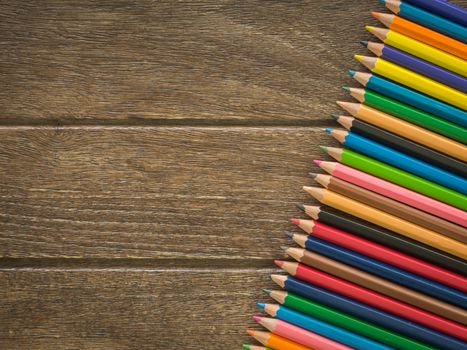 crayons put on a wooden board view from top. free space for text. educations concept, back to school concept.