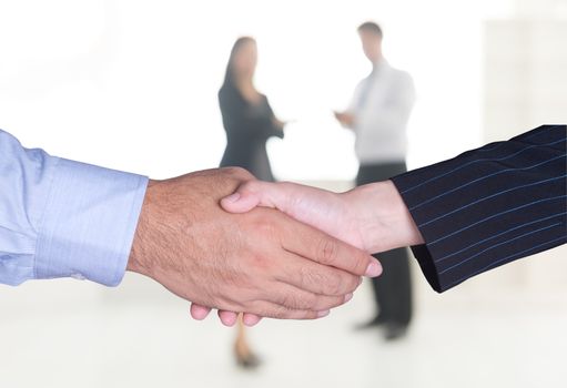 Closeup of a business handshake with office background.