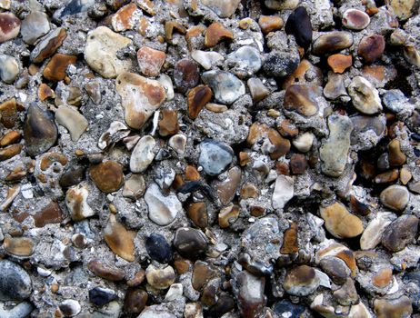 Background of Old Cobblestone Wall with Cracked Concrete, Small Stones Natural Dirties closeup Outdoors 