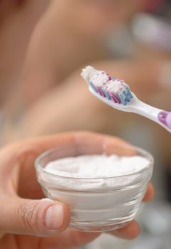 Woman brightening teeth with sodium bicarbonate