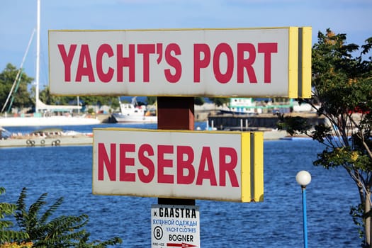 Nessebar, Bulgaria - July 16, 2016: Yacht's Port Of Nessebar Sign On A Pole in Nessebar. Bulgarian Black Sea Coast On The Background
