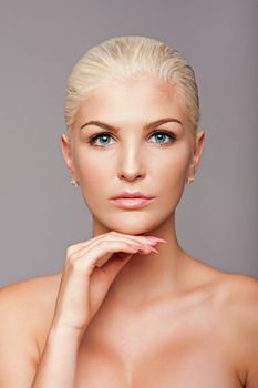 Beauty portrait face of beautiful blond woman with blue eyes and smooth skin, aesthetics skincare concept.