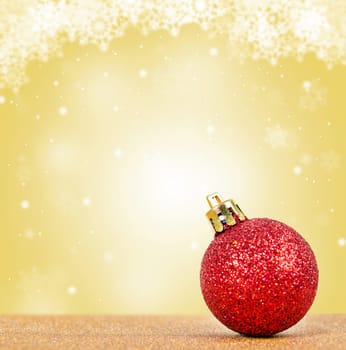 Glitter red ball on christmas yellow background.