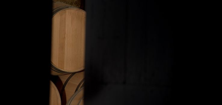 Barrels in a winery, through the door of cellar, Bordeaux Vineyard