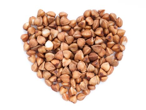 Background of heart-shaped buckwheat. Isolated on white. Top view or flat lay. Healthy food and diet concept