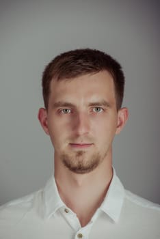 Portrait of a smiling young brunette man in studio