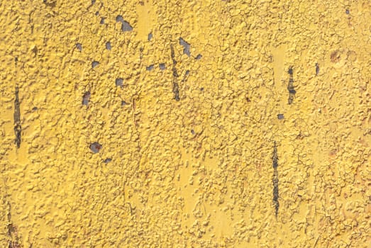 fragment of an iron surface is covered with yellow color paint, which has long been under the influence of different climatic conditions