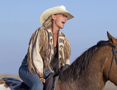 cowgirl on appaloosa horse on the beach