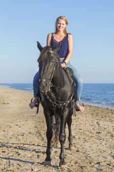 riding girl with her black  on the beach