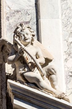 the statue of a cherub with a harp