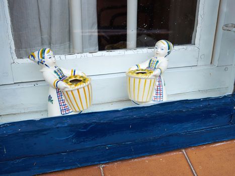 Classical vintage handmade European porcelain figurines in a window of a home