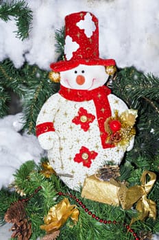 Toy snowman in red cap and scarf on the Christmas tree