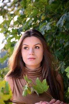 Polish forest with colorful leaves. Portrait of young female model with autumn scenery. 