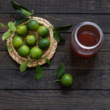 Green Kumquat fruit on wooden background, a popular agriculture product of Vietnam, rich vitamin c, healthy fruit