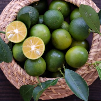 Green Kumquat fruit on wooden background, a popular agriculture product of Vietnam, rich vitamin c, healthy fruit