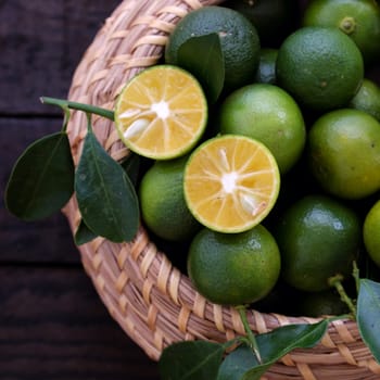 Green Kumquat fruit on wooden background, a popular agriculture product of Vietnam, rich vitamin c, healthy fruit