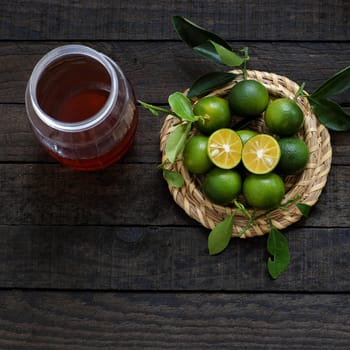 Green Kumquat fruit on wooden background, a popular agriculture product of Vietnam, rich vitamin c, healthy fruit