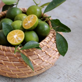 Green Kumquat fruit on wooden background, a popular agriculture product of Vietnam, rich vitamin c, healthy fruit