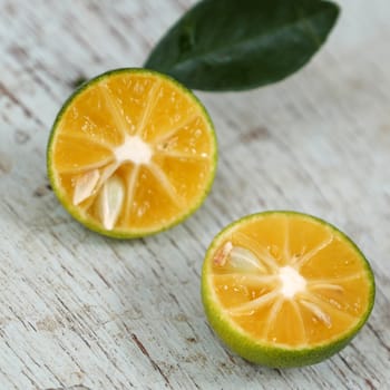 Green Kumquat fruit on wooden background, a popular agriculture product of Vietnam, rich vitamin c, healthy fruit