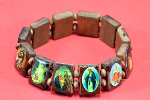 Bracelet in small pieces of wood decorated with small icons of religion.