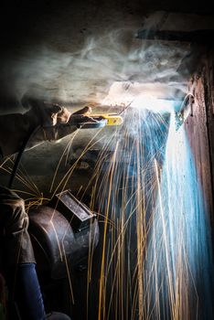 worker welding metal with sparks