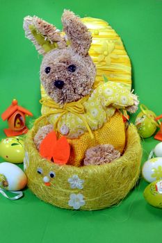 Rabbit of Easter in a basket in front of a green bottom.