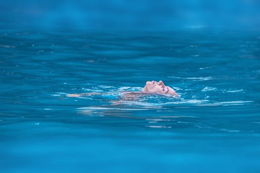 Woman floating and relaxing in tropical ocean water