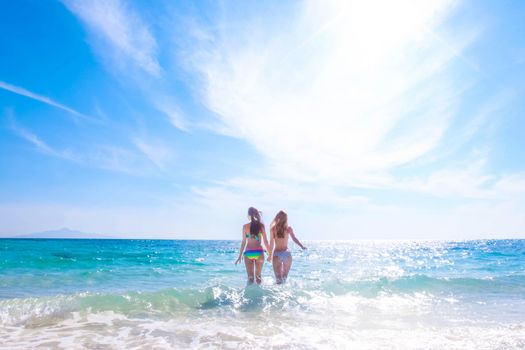 Beautiful fit women in bikni run to tropical sea