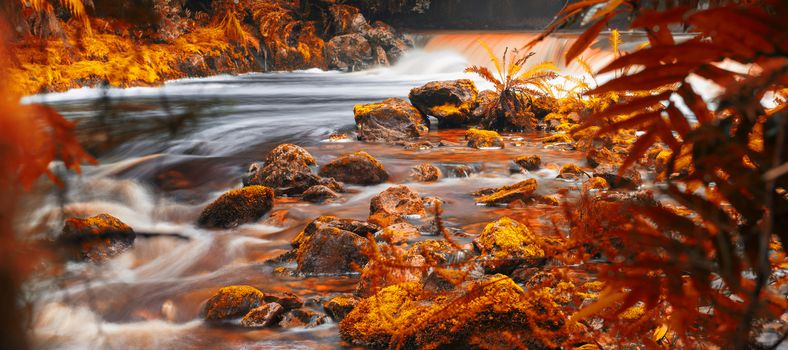 Newell creek in Tasmania, Australia is a magnificent fast running stream. Abstract landscape with red hues added.
