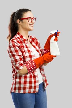 Pretty woman wearing gloves and holding a cleaning spray 