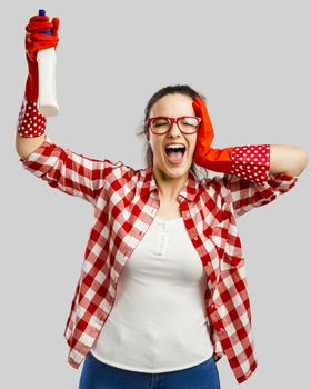 Pretty woman wearing gloves and holding a cleaning spray 