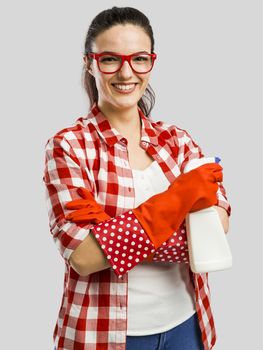 Pretty woman wearing gloves and holding a cleaning spray 