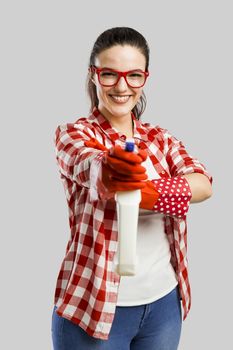 Pretty woman wearing gloves and holding a cleaning spray 