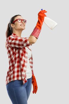 Pretty woman wearing gloves and holding a cleaning spray 