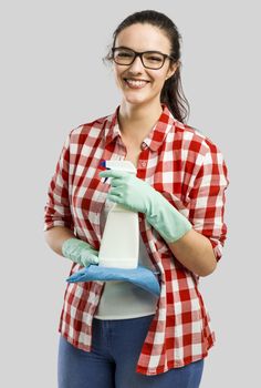 Pretty woman wearing gloves and holding a cleaning spray and a cloth