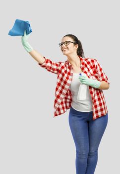 Pretty woman wearing gloves, using a cleaning spray and cleaning the house