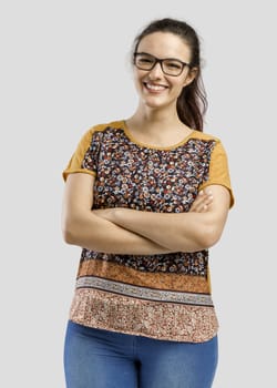 Studio portrait of a beautiful woman with arms holded, isolated over a gray background