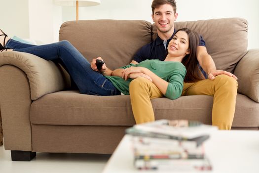 Young couple sitting on the sofa and watching movies