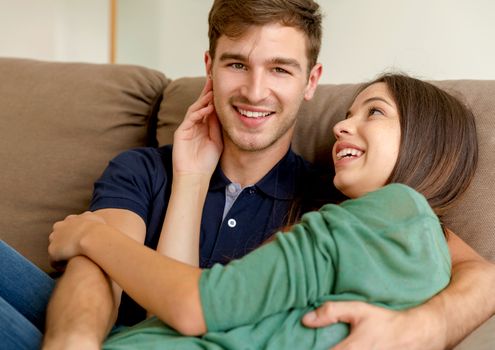 Young couple sitting on the sofa and dating