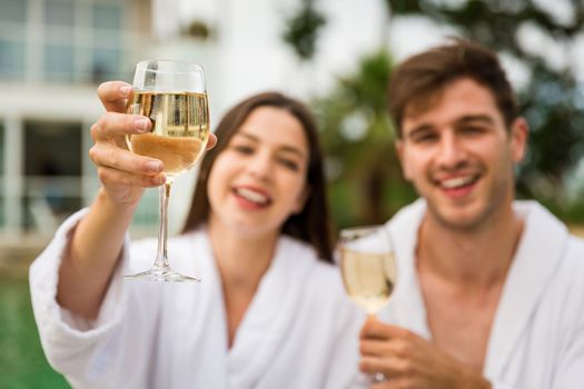 Young couple  in a luxury hotel tasting a glass of white wine