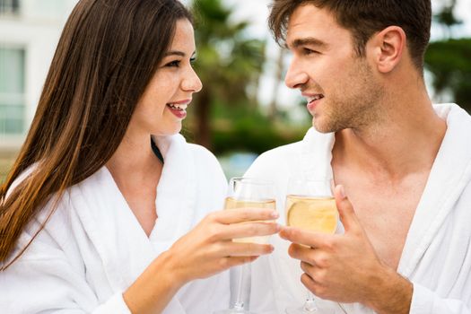 Young couple  in a luxury hotel tasting a glass of white wine