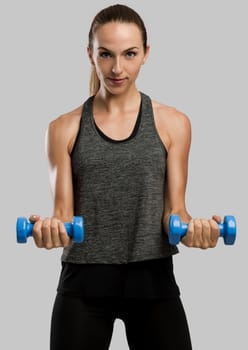 Young fitness woman making exercises with dumbbells