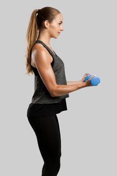 Young fitness woman making exercises with dumbbells