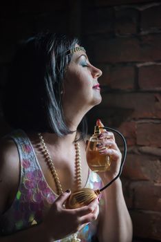 Beautiful woman with perfume bottle on black background