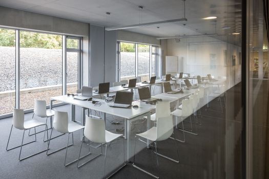 Interior of empty contemporary conference hall with white chairs.