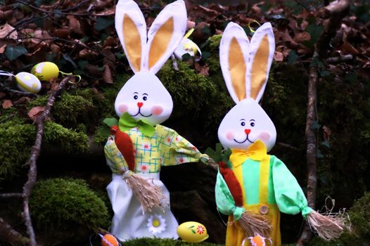 A couple of rabbit of Easter in the forest with eggs.