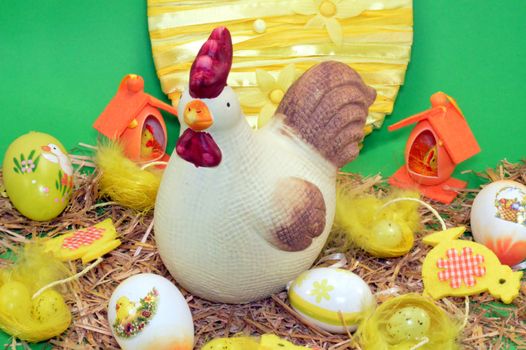 A hen of Easter with his chicks and eggs on the straw.