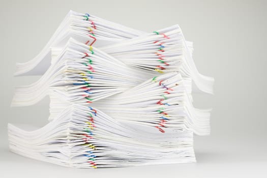 Pile overload of document with colorful paper clip place on white table.